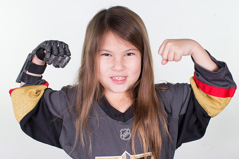 A girl holding both of her arms in the air.