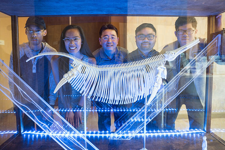 People standing in front of a museum display case.