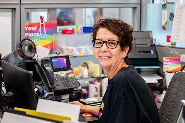 A staff member sitting a desk