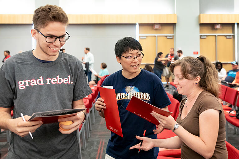 Two men and a woman talking to each other.