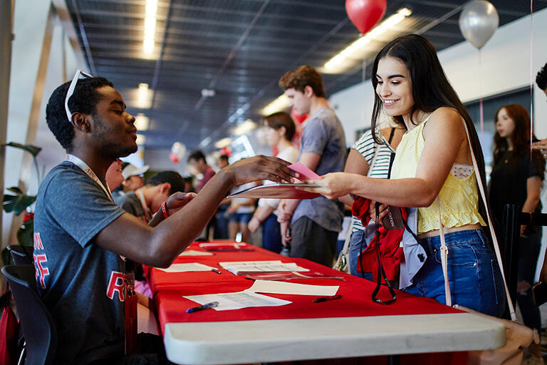A woman talking to a man at a booth.