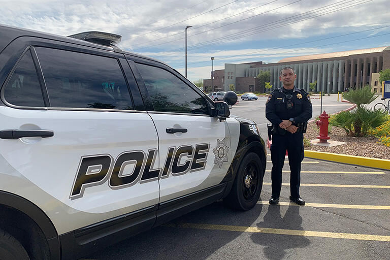 A police officer next to a patrol vehicle