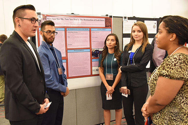 Students discussing a presentation board