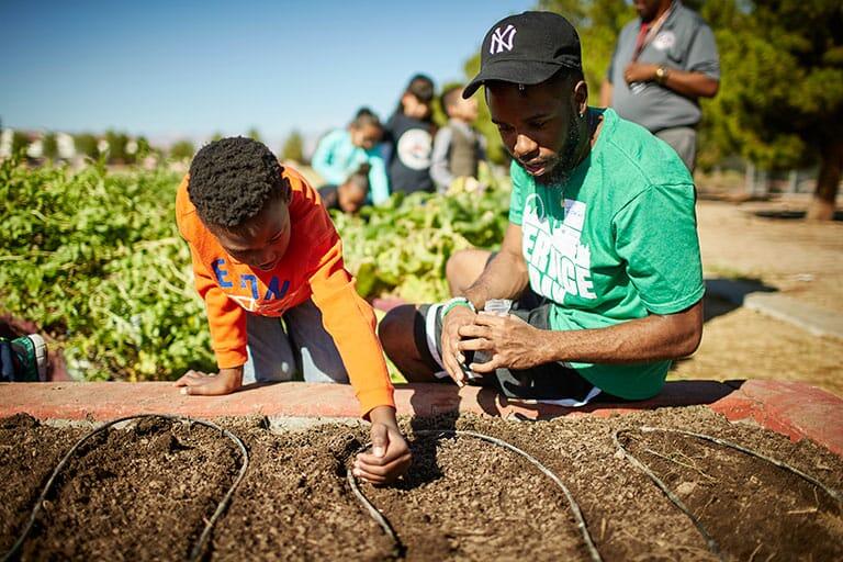 Child and adult working in a garden