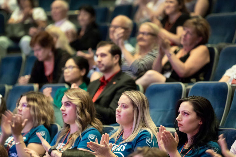 Students clap while watching a lecture