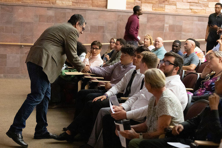 Faculty gather in a lecture hall