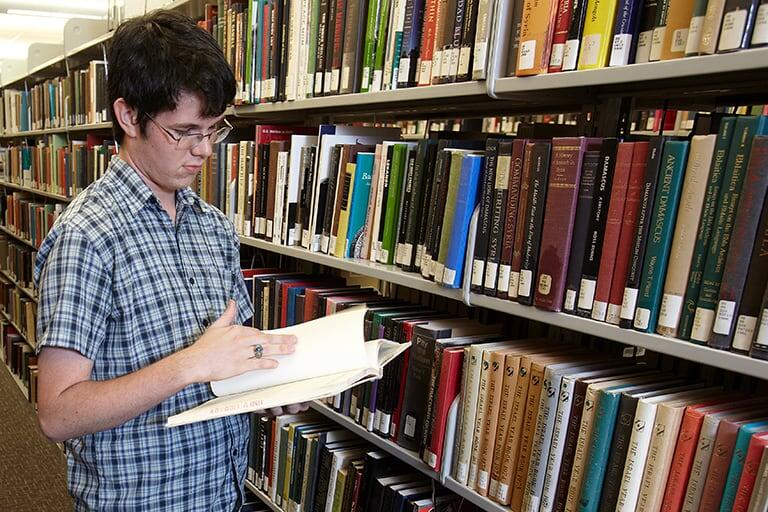Student viewing a book at a library