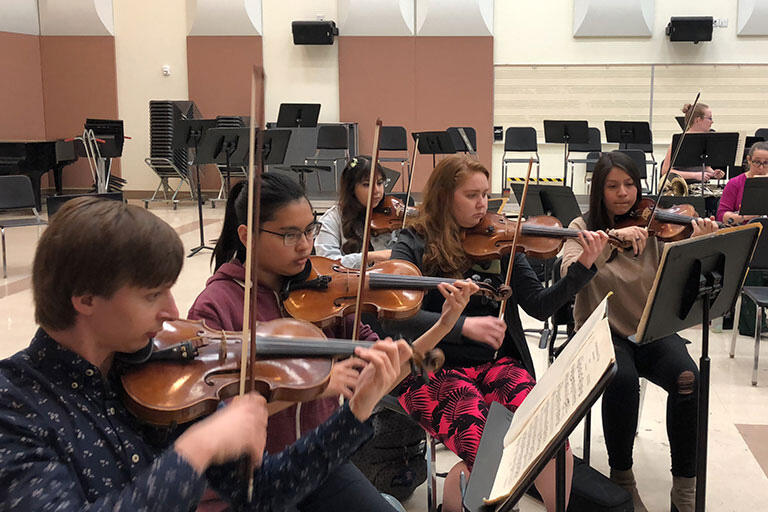 Students playing string instruments