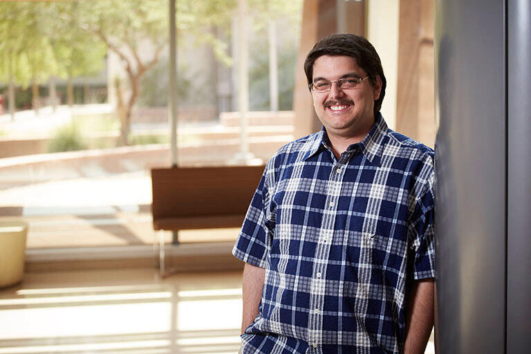 Person posing for picture while leaning against wall