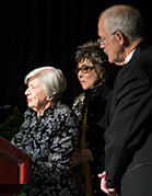 Three people standing behind a podium