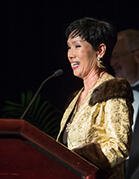 Sue Kim speaking behind a podium