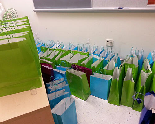 Green and blue paper bags on the table and floor