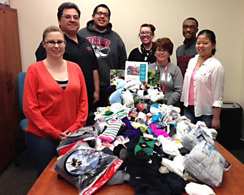 A group of people standing around a table covered with socks