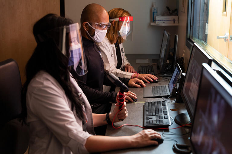 People with masks on using computers