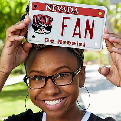 Girl holding license plate over her head