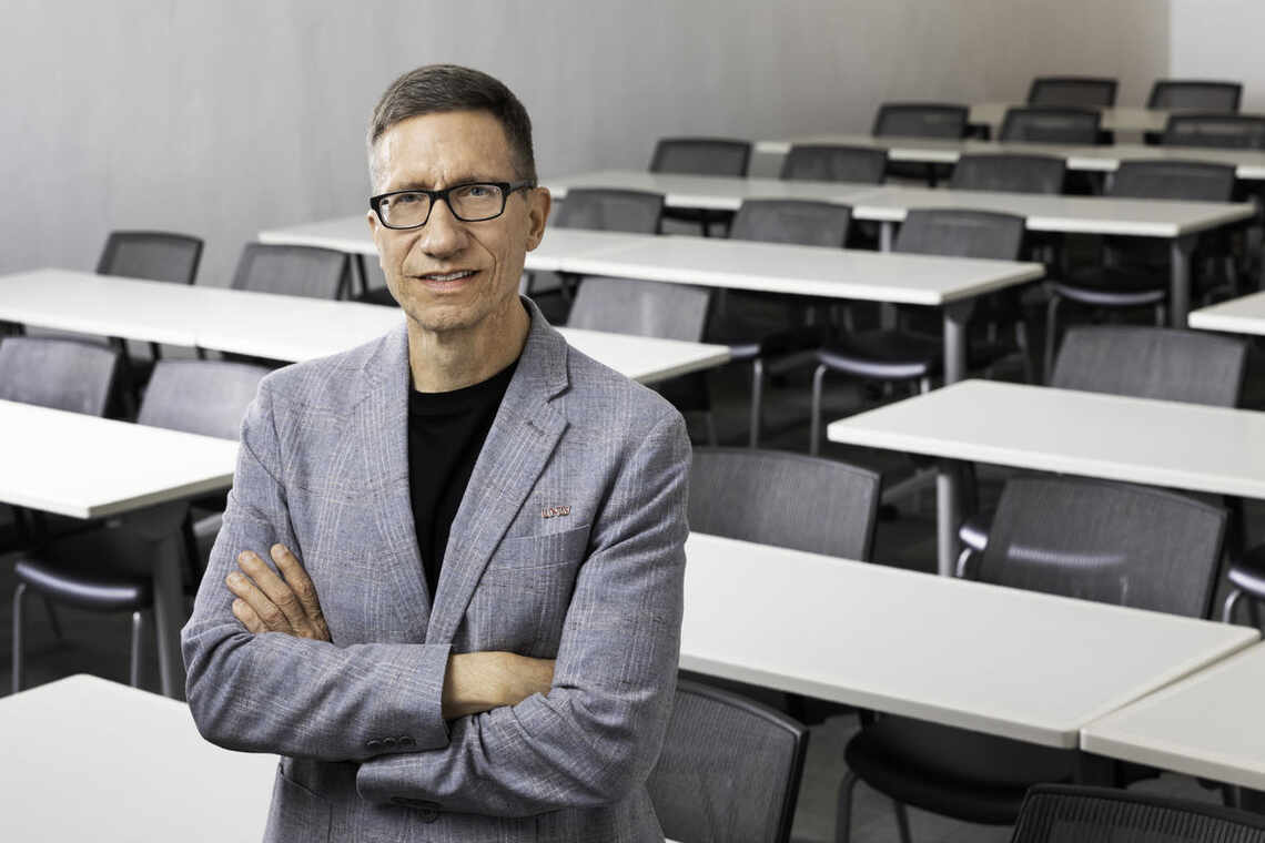 Geoff Hughes standing in an empty classroom