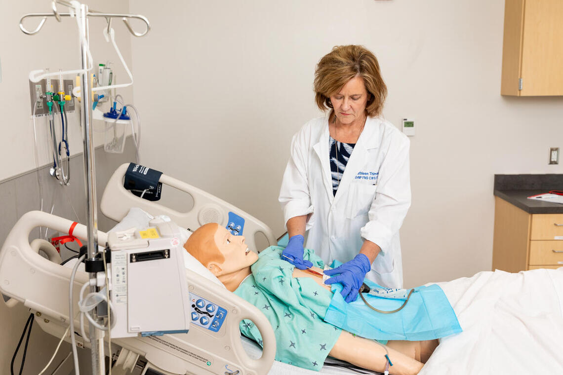 UNLV Nursing Professor Kathleen Thimsen practices wound care on simulation manikin