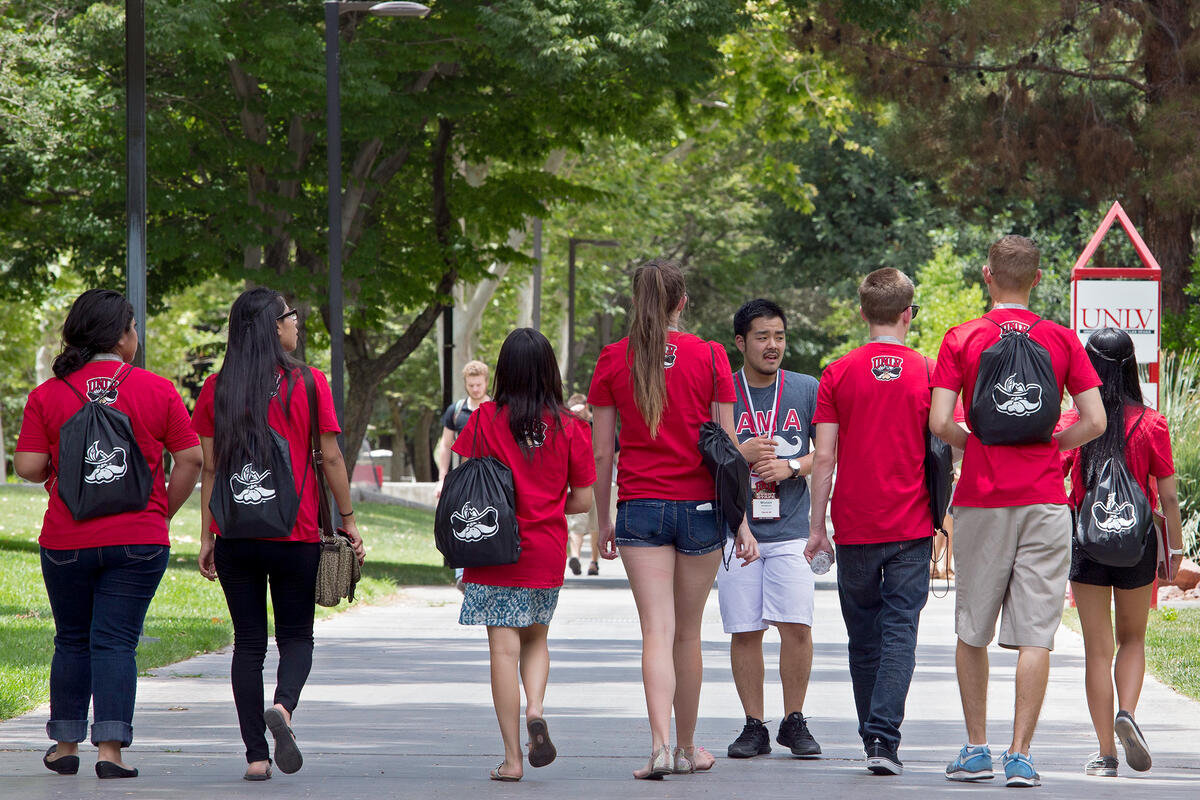 A tour guide shows a group of students the campus