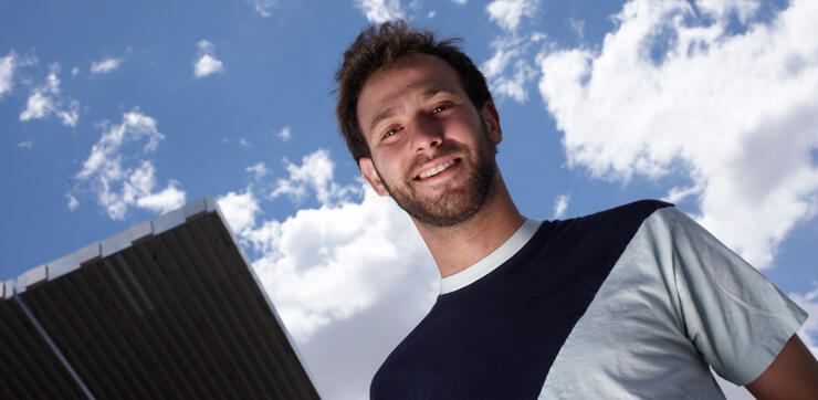 Engineering graduate poses by solar array