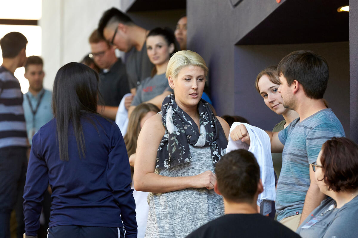 A woman speaks with her classmates