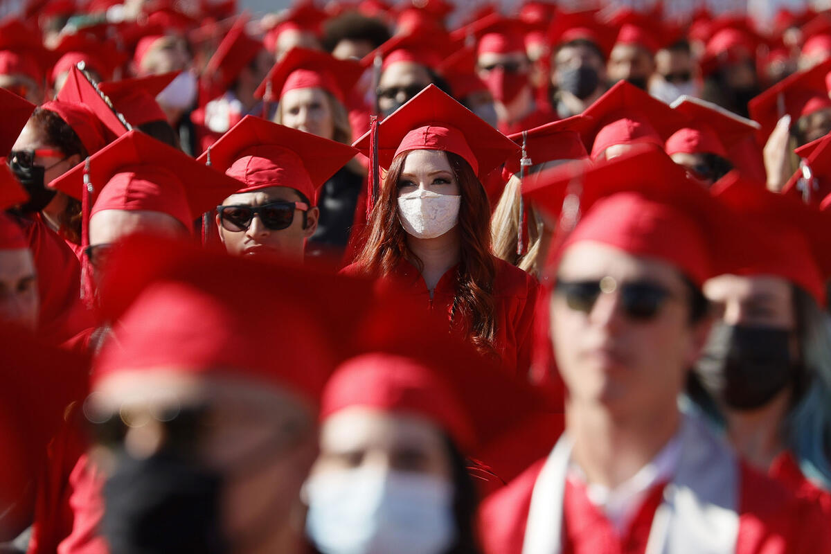 Large group in regalia with focus on woman in center