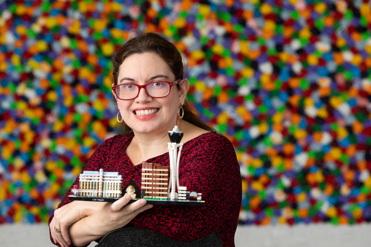 A woman holds up a Lego version of the Las Vegas Strip