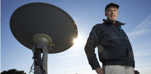 Bob Boehm stands next to solar array