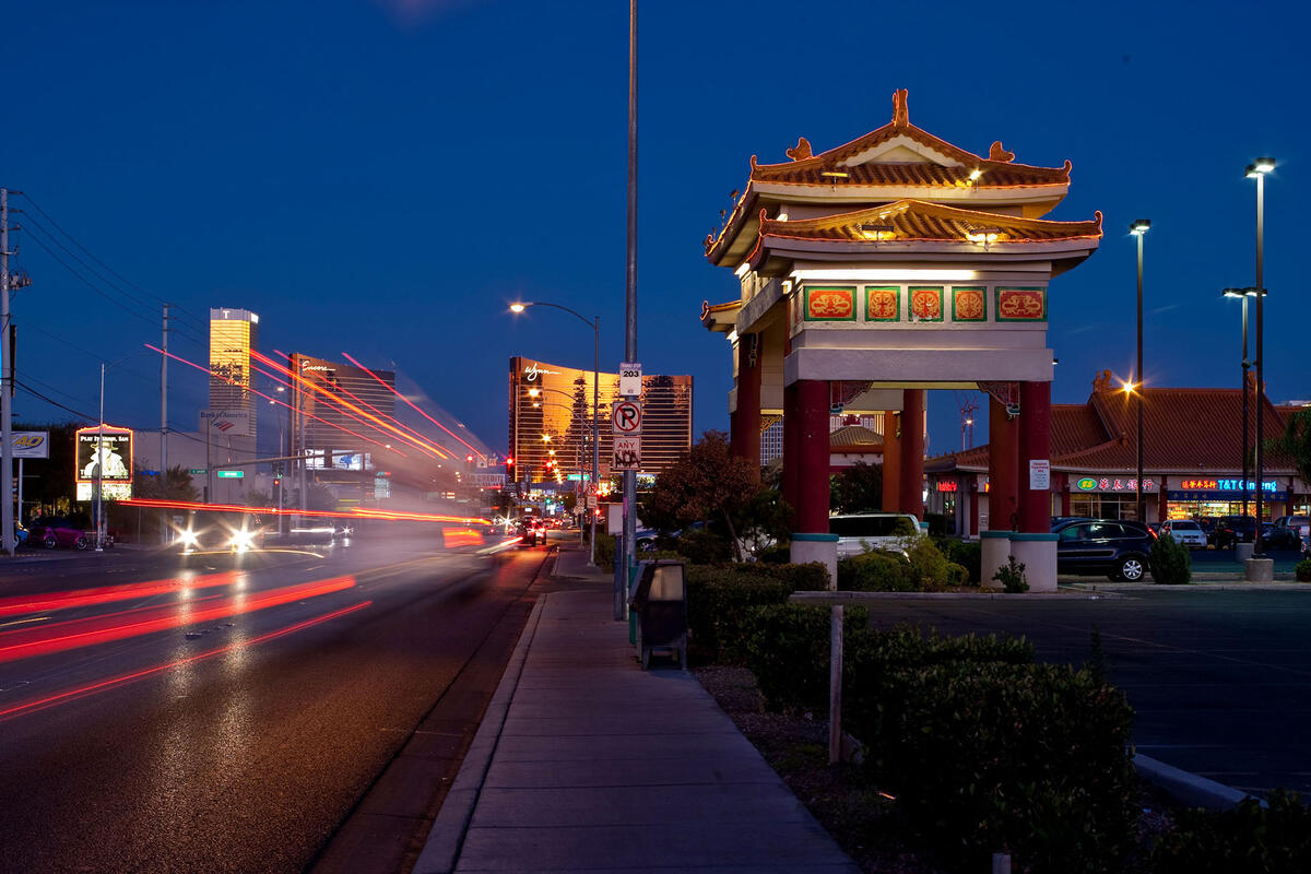 Commercial building with Asian architecture at night with car lights streaming