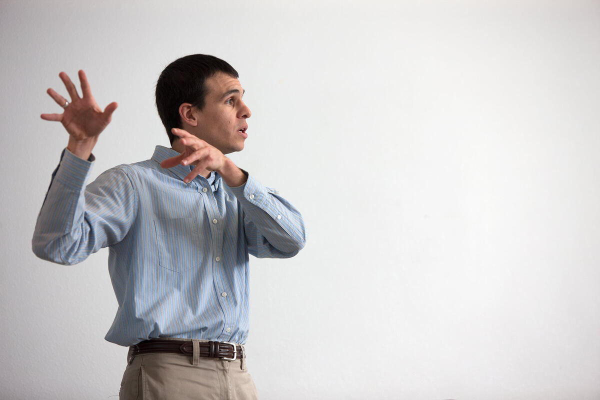 man gestures while teaching