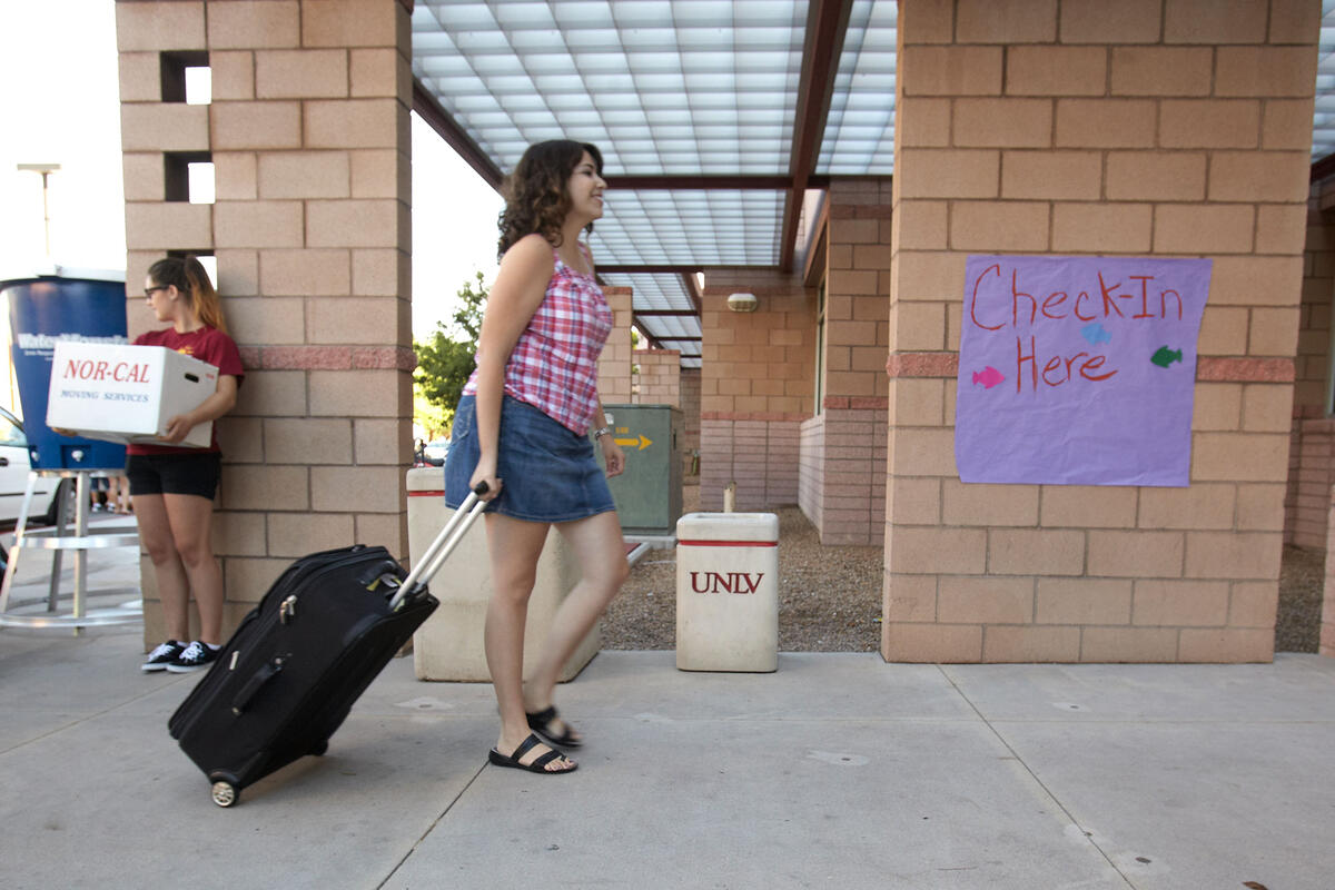 Student walking her luggage.