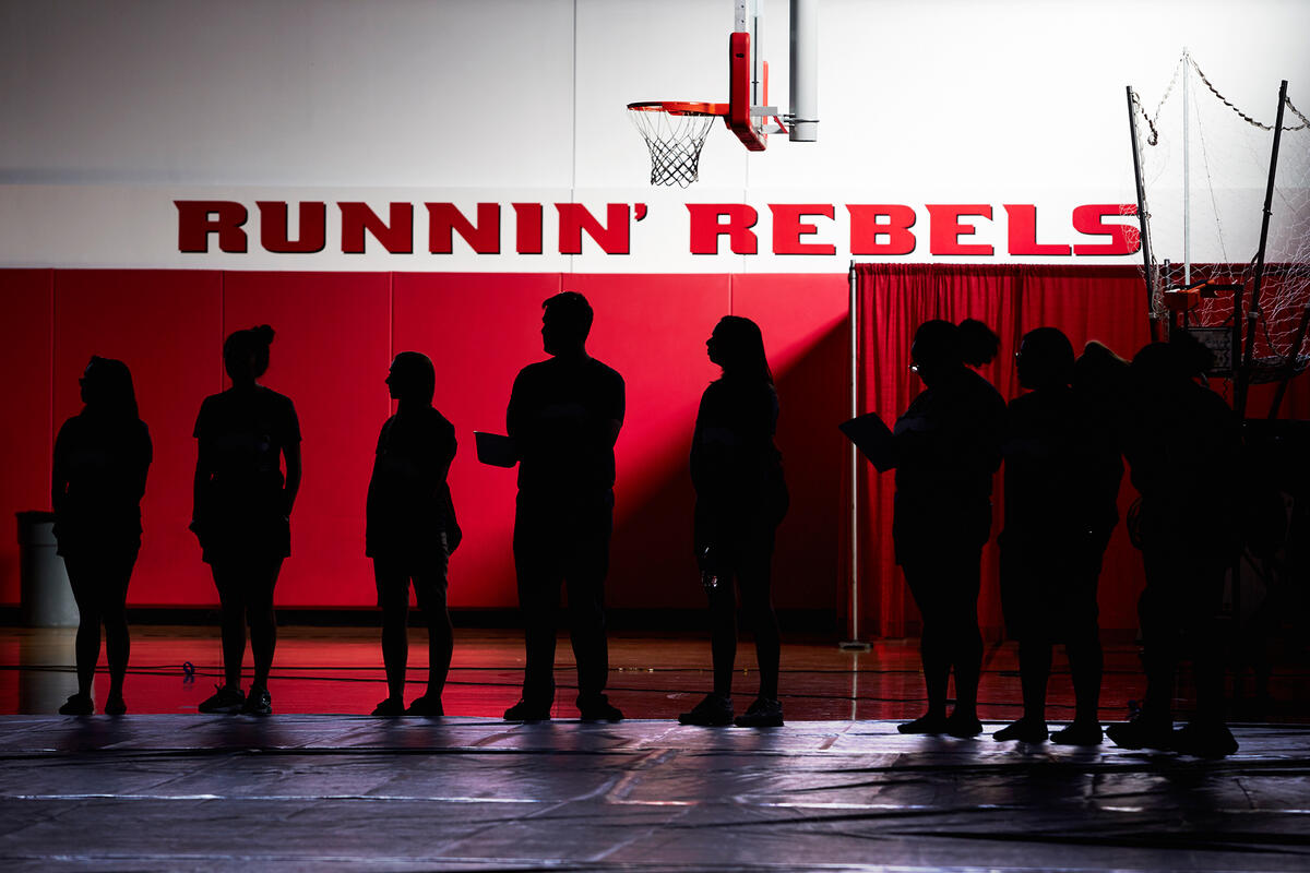 Silhouettes of students inside of basketball gym.