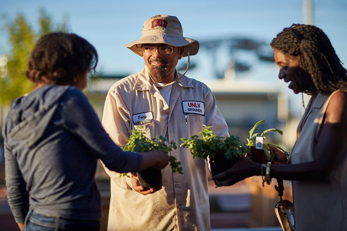 Antonio Duron and volunteers, holding plants