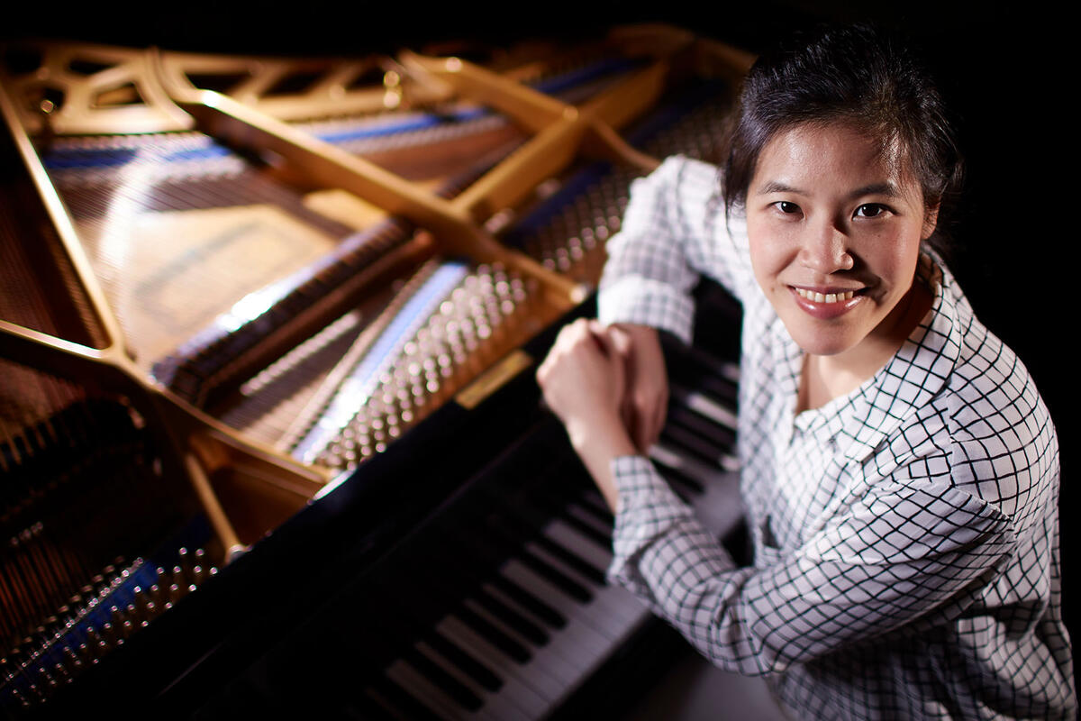 Cynthia Wong sits at a piano