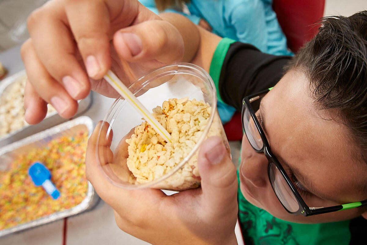 Student measures a cup of Rice Crispies