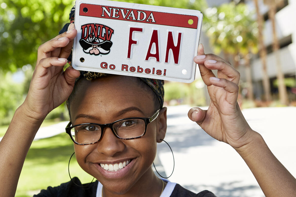 Mecca Walker holds up UNLV license plate