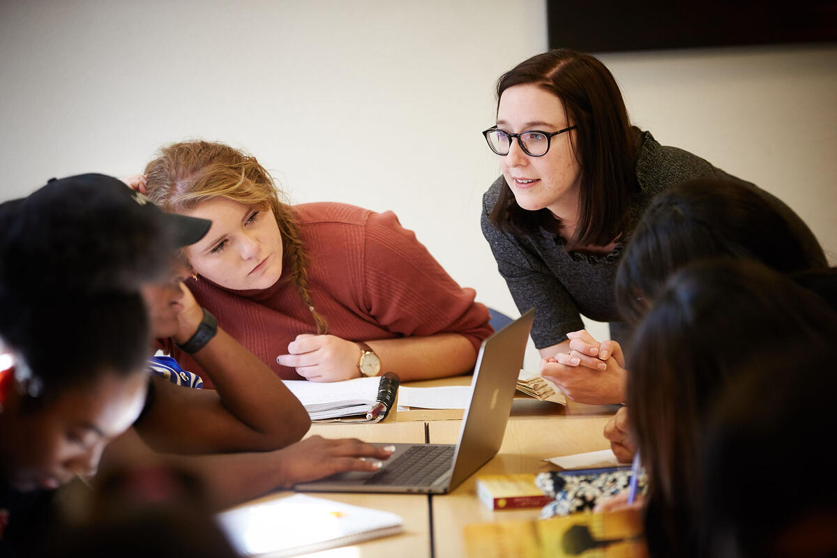 Emily Shreve working with students at table. 