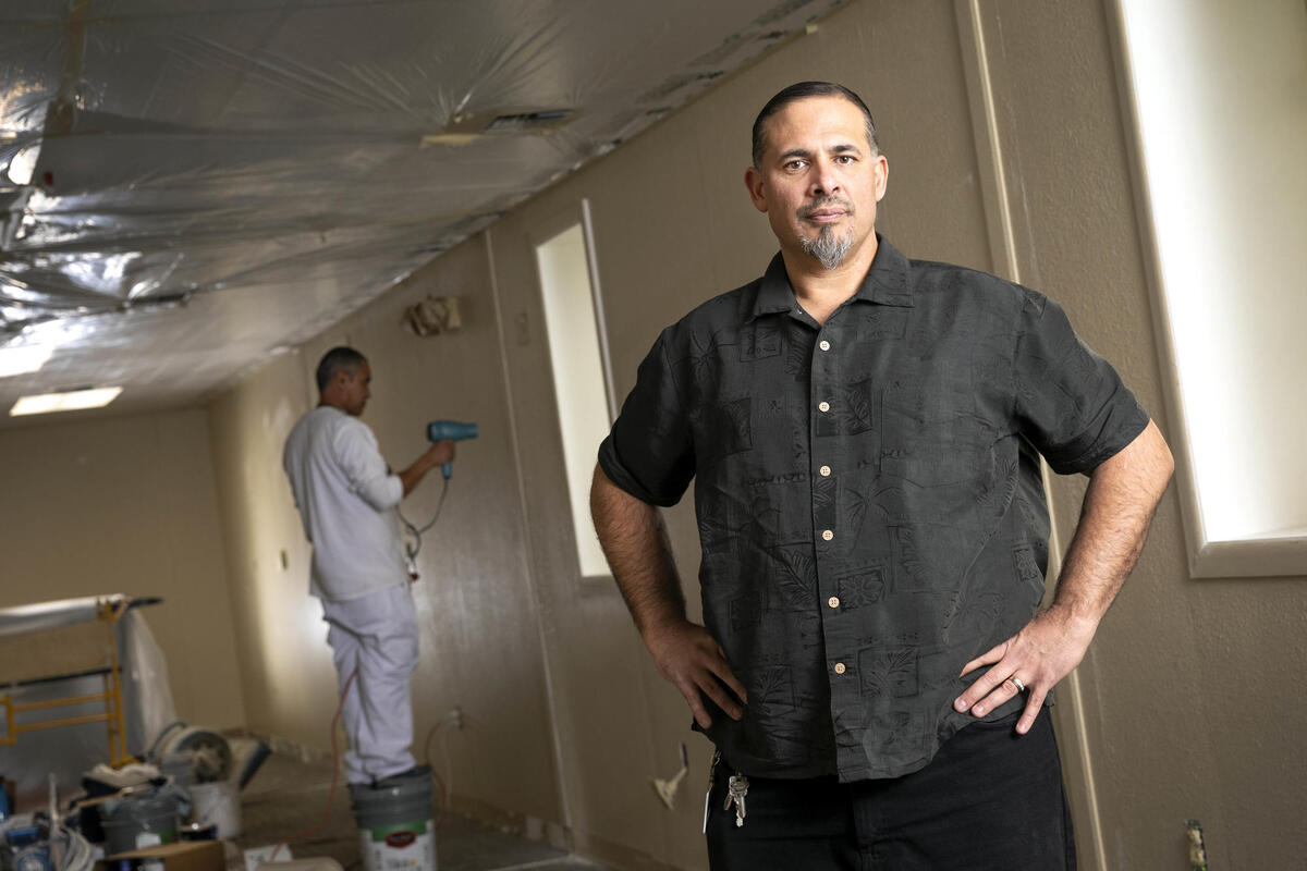 Chadwick "Chad" Phillips poses in front of construction in a building.