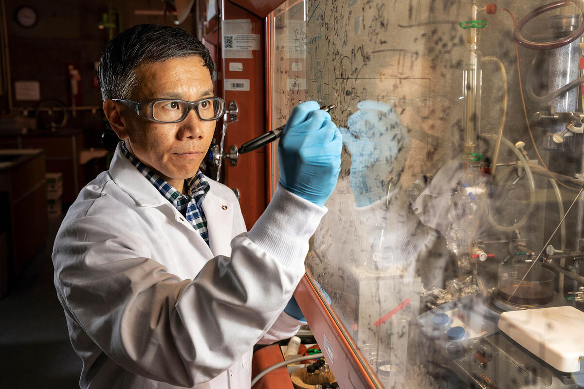 Jun Yong Kang writes on a glass board.