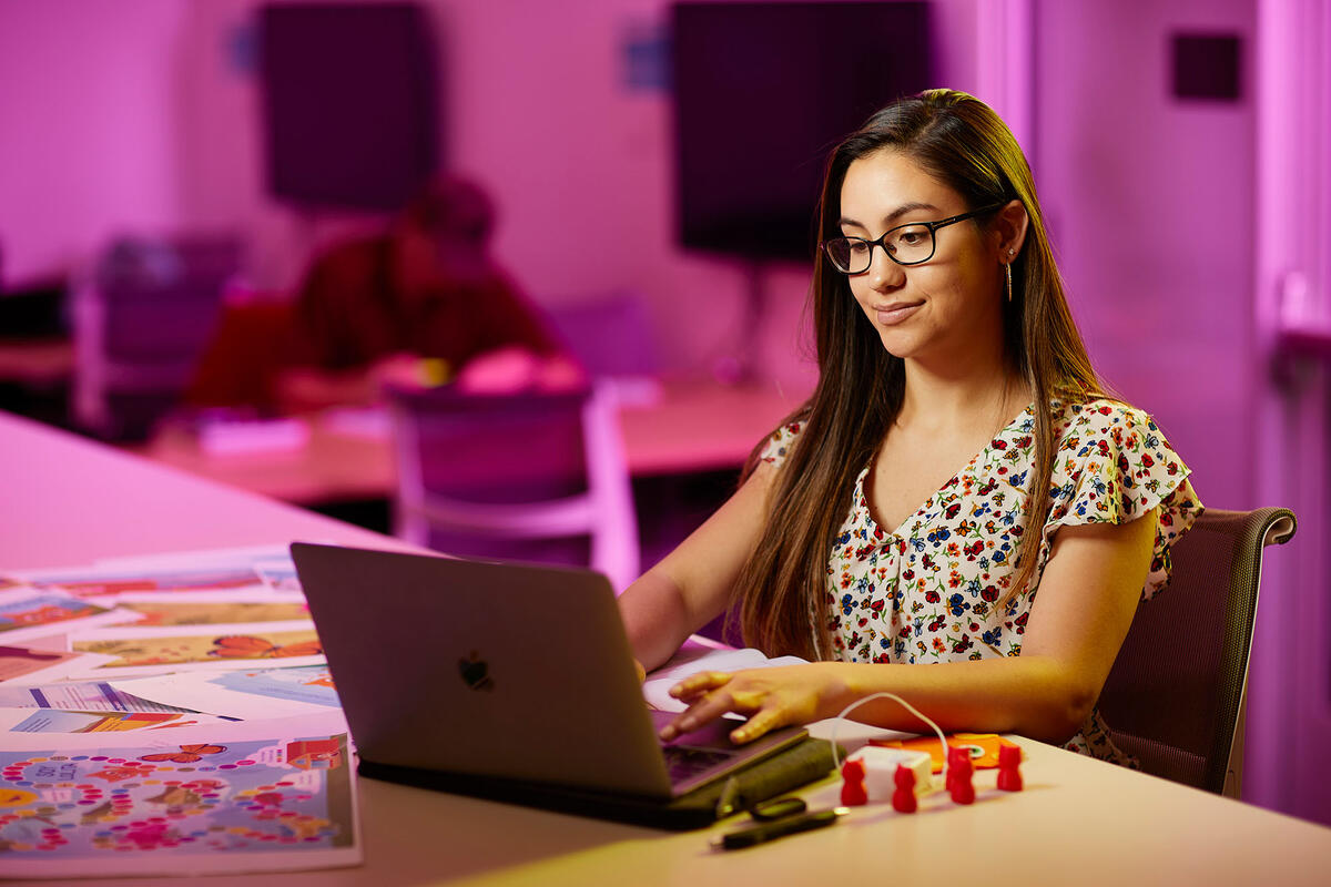 Christen Lena Gomez working at her computer.