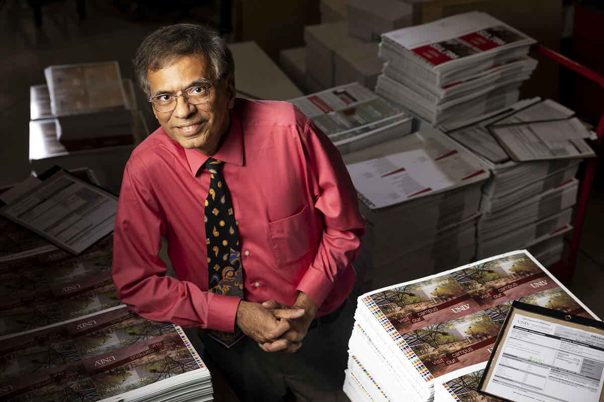 Abbas Badani poses in front of UNLV's printouts.