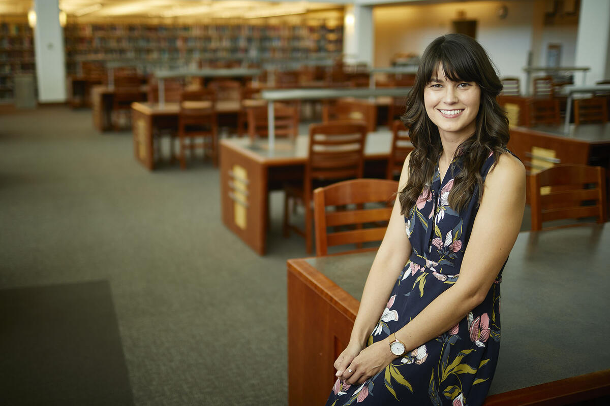 Chelsea Heinbach standing in the library.