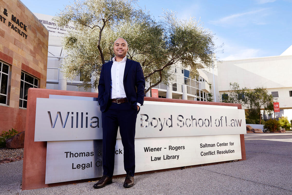 Cameron Lue-Sang standing in front of William Boyd School of Law sign.