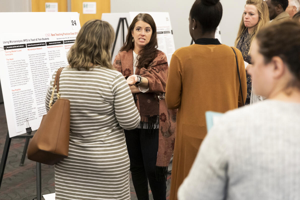 woman leading discussion at poster presentation