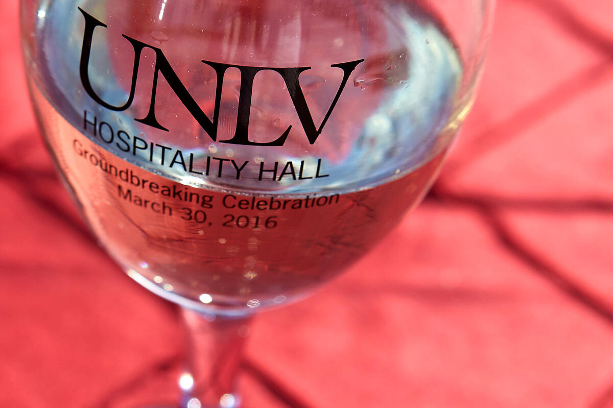Overhead view of a glass of water with UNLV logo on it.