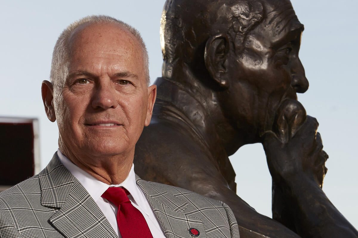 Chip Johnson standing behind a statue