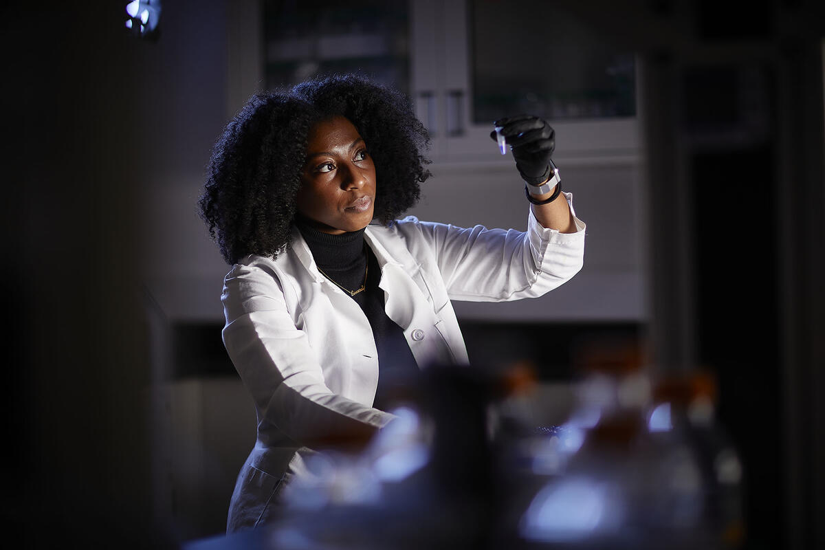 woman in lab coat looking at a sample