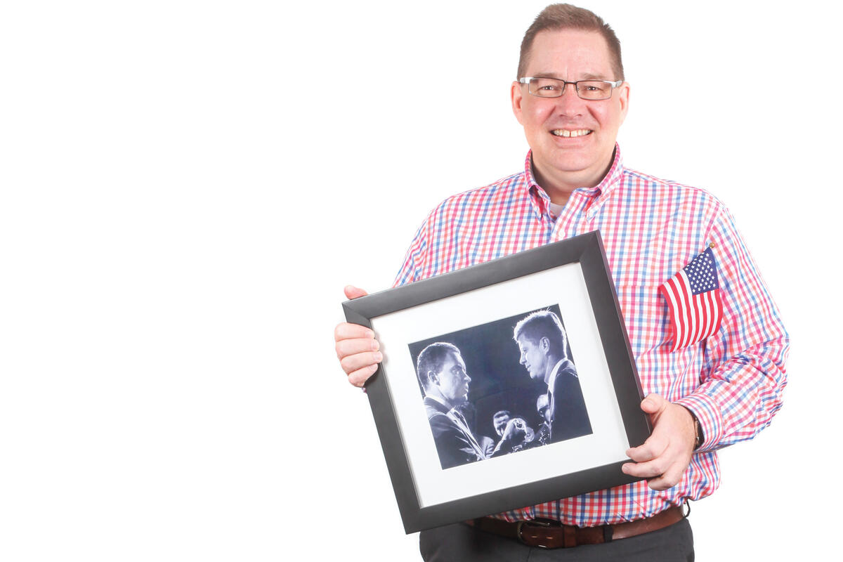 Mitchell McKinney holds a photo of Kennedy and Nixon