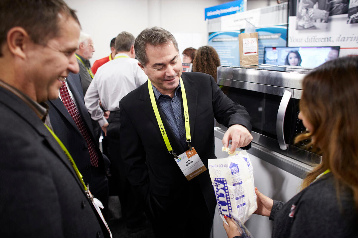President Len Jessup eating a piece of popcorn at the CES convention