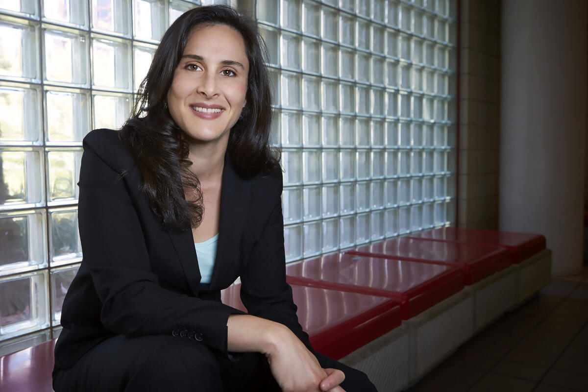 Lydia Nussbaum sits on a bench in front of a window.