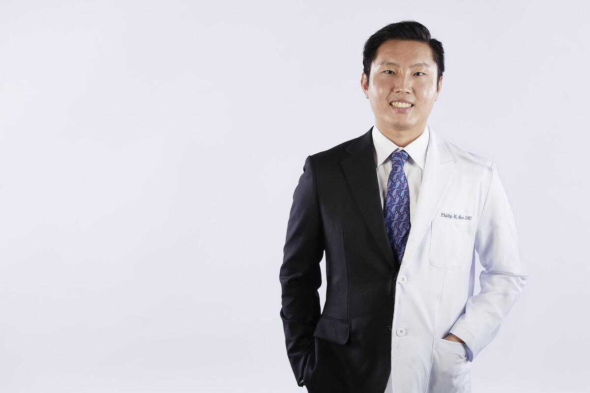 Photo of Phillip Son wearing a suit and coat